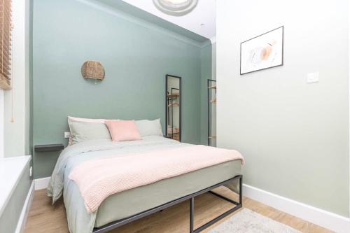 1 dormitorio con 1 cama con manta rosa en Coastline Retreats - Verulum Apartments - Beautifully Designed Luxury Town Centre Apartments - 5 minute walk to the beach - Parking included en Bournemouth