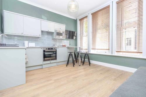a kitchen with white cabinets and white appliances at Verulum Apartments - FREE PARKING INCLUDED - 9 mins walk to the beach - Beautifully Designed Luxury Town Centre Apartments by Coastline Retreats in Bournemouth