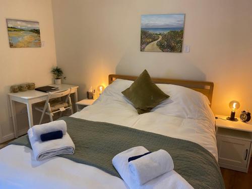 a bedroom with a large bed with towels on it at The Ivy Barn Holbeton in Plymouth