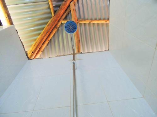 a shower in a room with a tile floor at Mutanda Eco Community Center in Kisoro