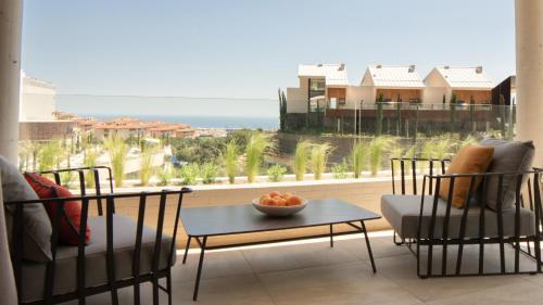 a balcony with two chairs and a table with a bowl of fruit at Leiro Residences - Preferred Hotels & Resorts in Fuengirola