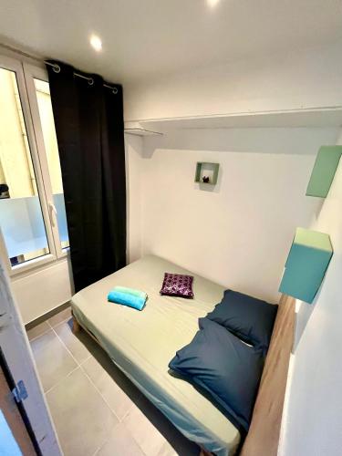 un petit lit dans une chambre avec une fenêtre dans l'établissement Appartement 3 pièces GREEN ART ****, au Cannet