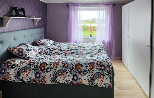 1 Schlafzimmer mit einem Bett mit einer Blumendecke und einem Fenster in der Unterkunft Pet Friendly Home In Borgholm With Wifi in Borgholm