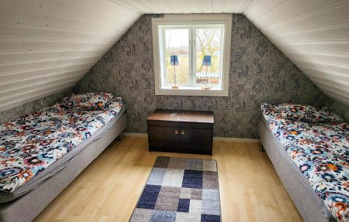 2 Betten in einem Dachzimmer mit Fenster in der Unterkunft Pet Friendly Home In Borgholm With Wifi in Borgholm