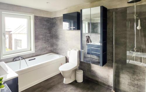 ein Badezimmer mit einer Badewanne, einem WC und einem Waschbecken in der Unterkunft Pet Friendly Home In Borgholm With Wifi in Borgholm