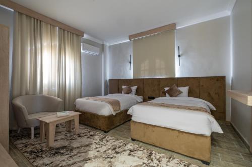 una habitación de hotel con 2 camas y una silla en Golden House en El Cairo