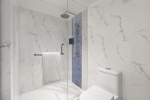 a bathroom with a toilet and a glass shower at Four Points by Sheraton Boracay in Boracay