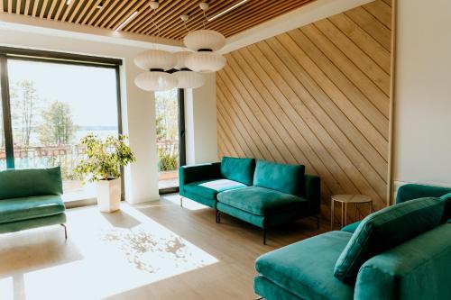 uma sala de estar com mobiliário verde e uma grande janela em Ośrodek Wczasowy Helena em Kruklanki