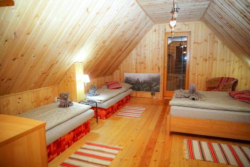 una camera con tre letti in una cabina di legno di Chata Molik a Lom nad Rimavicou