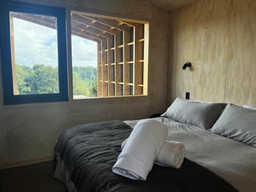 a bedroom with a large bed with a window at Cabaña en Rio Maullin Nek #1 in Las Quemas del Salto