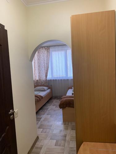 a room with a bedroom with a window and a door at Hostel Iskra in Lviv