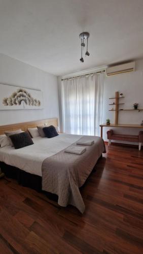 sypialnia z dużym łóżkiem i oknem w obiekcie Casa Maria w mieście Olivenza