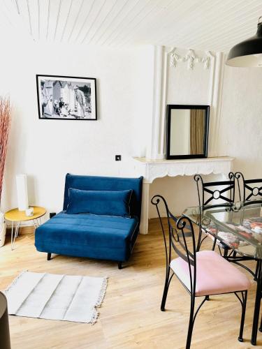 un salon avec un canapé bleu et une table en verre dans l'établissement Le Perchoir Du Parc Cœur historique Anduze 3 Etoiles, à Anduze