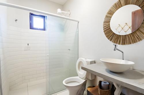 a bathroom with a sink and a toilet and a mirror at Flat 01 · Flats Japaratinga1- 200m da praia cozinha completa in Japaratinga