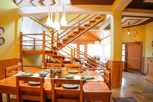 a dining room with a table and a staircase at Tropical Wood Villa in Manāli