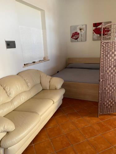 a living room with a couch and a bed at Frichi house in Lampedusa