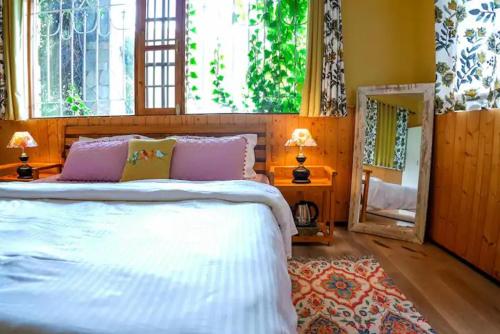 una camera con un grande letto e uno specchio di Tropical Wood Villa a Manāli
