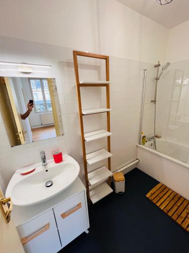 une salle de bain avec un lavabo blanc et un miroir dans l'établissement Jacqueline, à Étretat