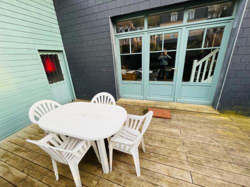 a white table and chairs sitting on a patio at Jacqueline in Étretat