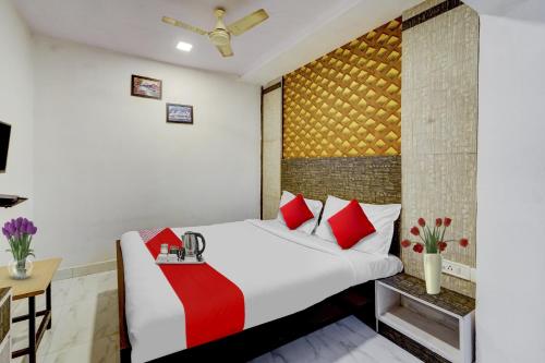a bedroom with a large bed with red pillows at OYO Flagship White Inn Near Golden Tower in Chennai