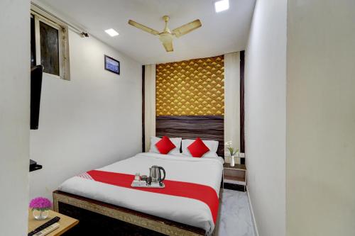 a hotel room with a bed with red pillows at OYO Flagship White Inn Near Golden Tower in Chennai