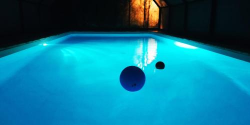einen Pool mit blauen Lichtern in einem Zimmer in der Unterkunft Le presbytère in Saint-Julien-lès-Montbéliard