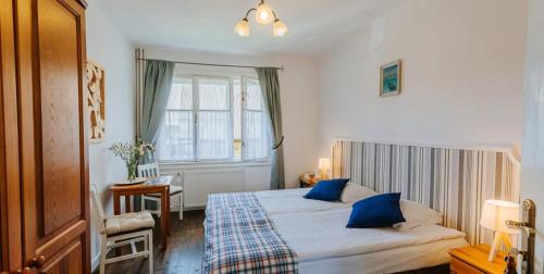 a bedroom with a large bed with blue pillows at Willa Zwolakówka in Istebna