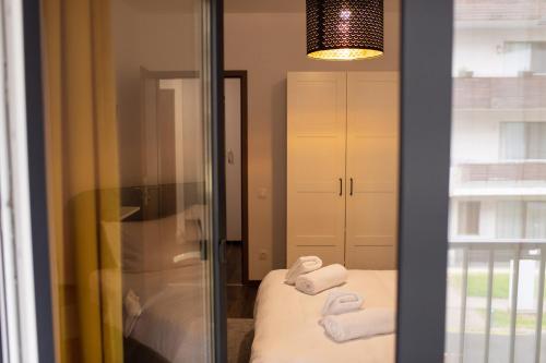 a room with a bed with towels and a mirror at Aria Sophia in Cluj-Napoca