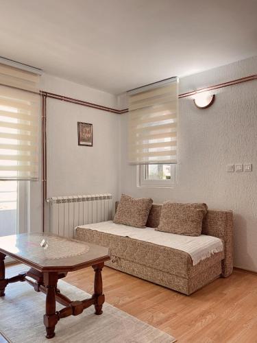 salon z kanapą i stołem w obiekcie Apartman Konatar w mieście Cetynia