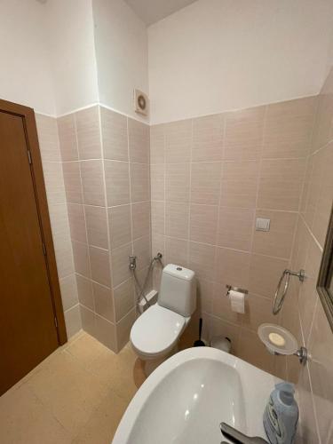 a bathroom with a toilet and a sink and a tub at Cozy Mountain Apartment in Borovets
