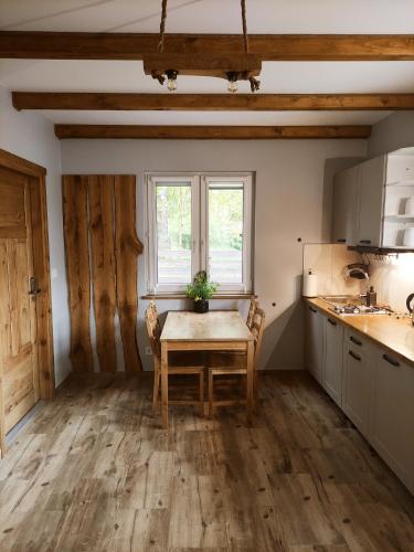 a kitchen with a table and a window in it at przy lesie in Białowieża