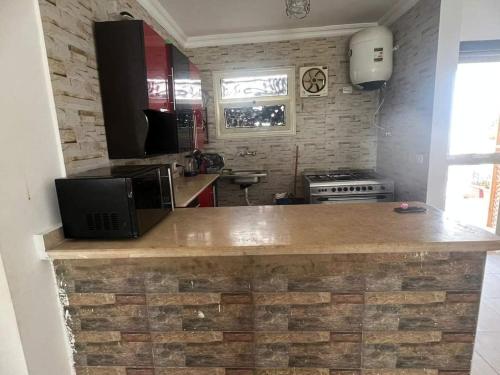 eine Küche mit einer Theke und einem TV darauf in der Unterkunft Lasriena Ras Sedr-Family Only in Ras Sudr