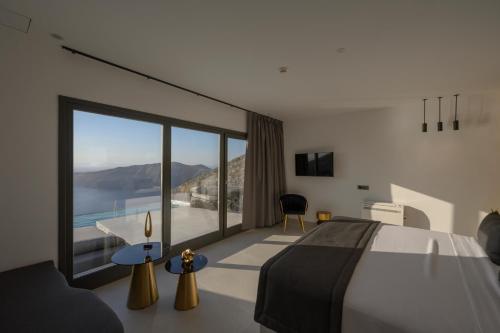 a bedroom with a large bed and a large window at Arany Terra in Imerovigli