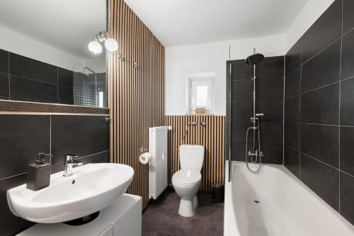 a bathroom with a sink and a toilet and a bath tub at Top floor apartment next to Marienplatz in Munich