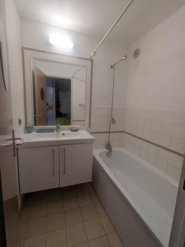 a bathroom with a tub and a sink and a mirror at Studio cosy vue et front de mer in Sète