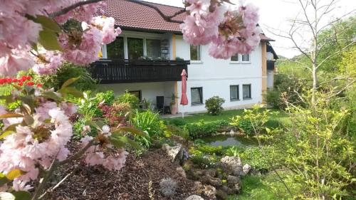 een huis met roze bloemen in de tuin bij Haus Christof 