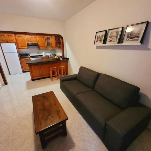 a living room with a green couch and a table at Casa Pancho Lanzarote in Playa Honda