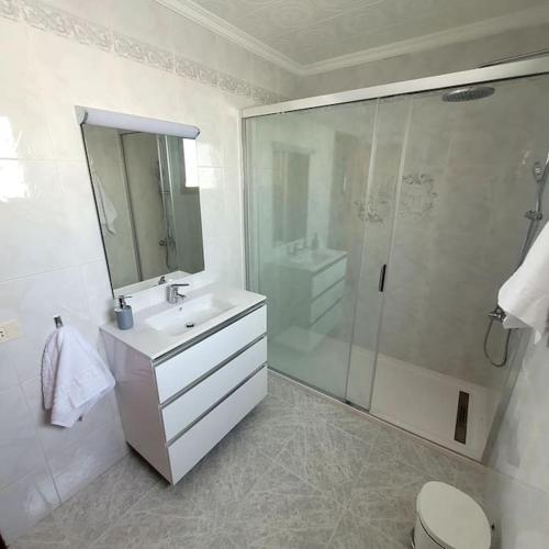 a white bathroom with a shower and a sink at Casa Pancho Lanzarote in Playa Honda