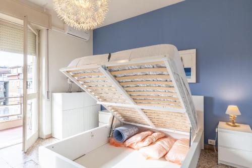 Cama blanca en habitación con escalera en Casa di Elena Marina di Carrara, en Marina di Carrara