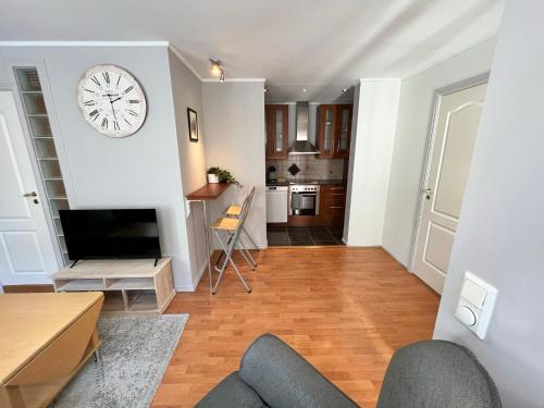 uma sala de estar com um relógio na parede em Central 1BR Apartment em Narvik