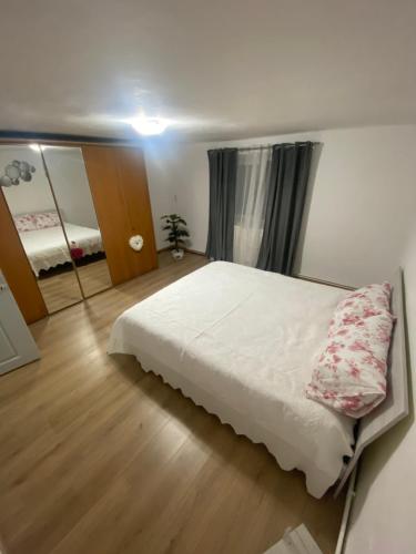 a bedroom with a white bed and a mirror at House Bumba in Baia Mare