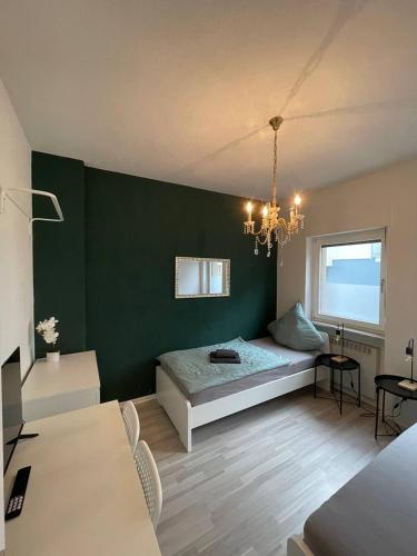- une chambre avec un lit et un mur vert dans l'établissement Charmante Wohnungen direkt in der Stadtmitte, à Andernach