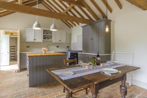 a kitchen with a wooden table in a room at Pea Cottage in Stamford