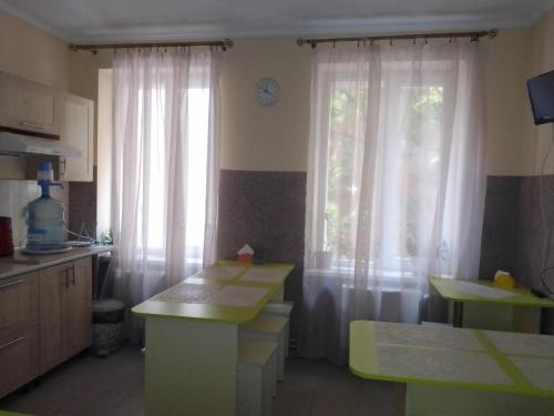 eine Küche mit weißen Vorhängen und einem Fenster in der Unterkunft Hostel Iskra in Lwiw