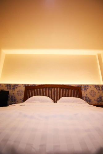 メーサリエンにあるBK Hotelの白いシーツが敷かれた大きなベッドのある寝室