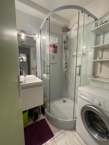 une salle de bain avec douche et machine à laver dans l'établissement Paradis du Soleil-plage de la roquille - 4 personnes- clim-parking, au Cap d'Agde
