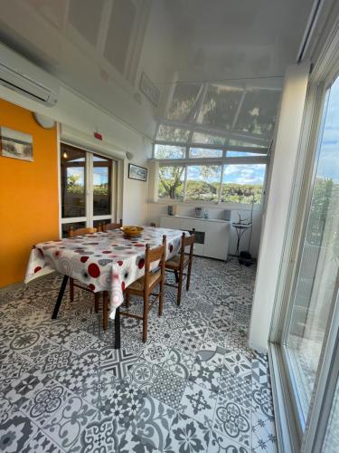 une salle à manger avec une table et des chaises et une cuisine dans l'établissement Paradis du Soleil-plage de la roquille - 4 personnes- clim-parking, au Cap d'Agde