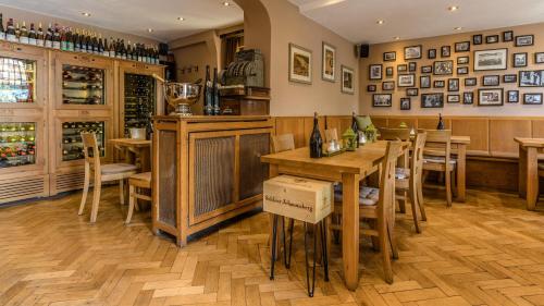 a restaurant with wooden tables and chairs and a bar at Weinhotel des Riesling Zum Grünen Kranz in Rüdesheim am Rhein