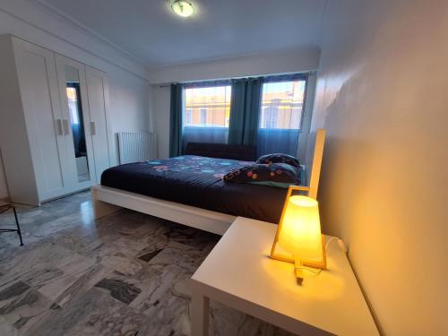 une chambre avec un lit et une table avec une lampe dans l'établissement L Alicante Carré d'Or 2 pieces Terrasse Climatise, à Menton