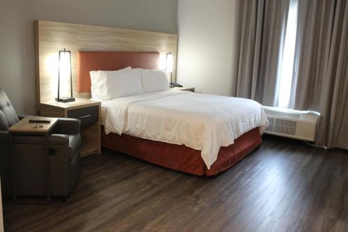 a hotel room with a large bed and a chair at Candlewood Suites - Nashville South, an IHG Hotel in Nashville